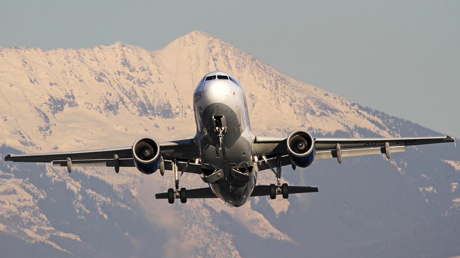 Close-up of an Airbus A319 CJ with a mountain in the background.